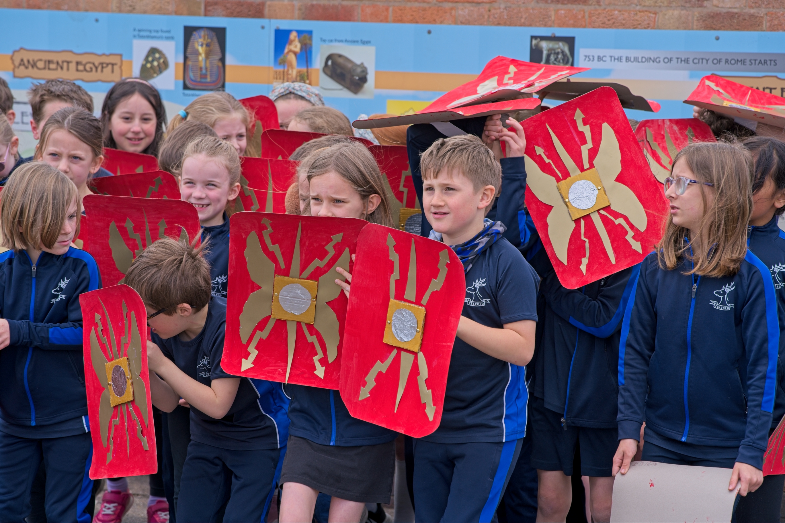 Children in Roman battle formation with shields they have made.