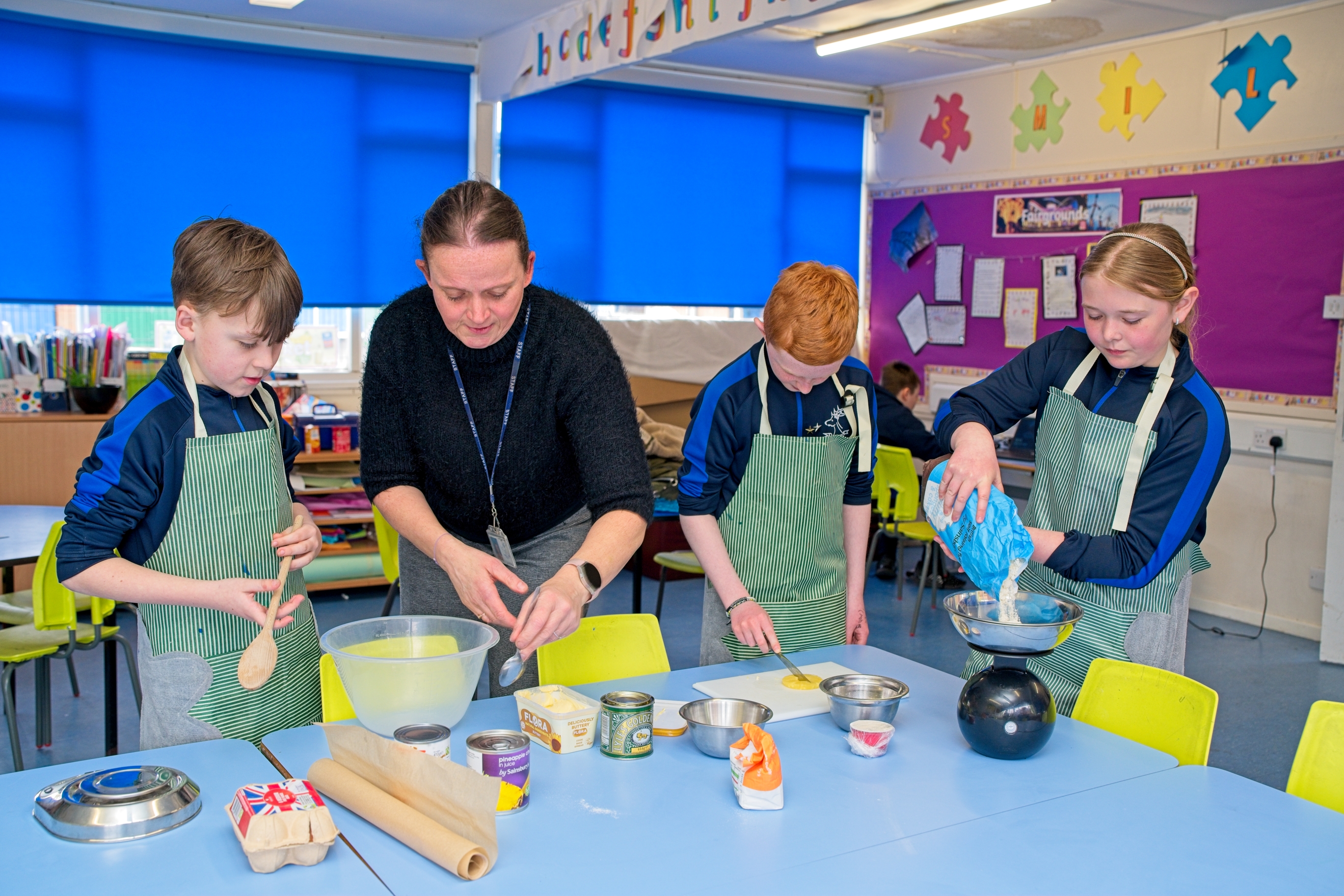 Children involved in a  cookery activity with the teacher.