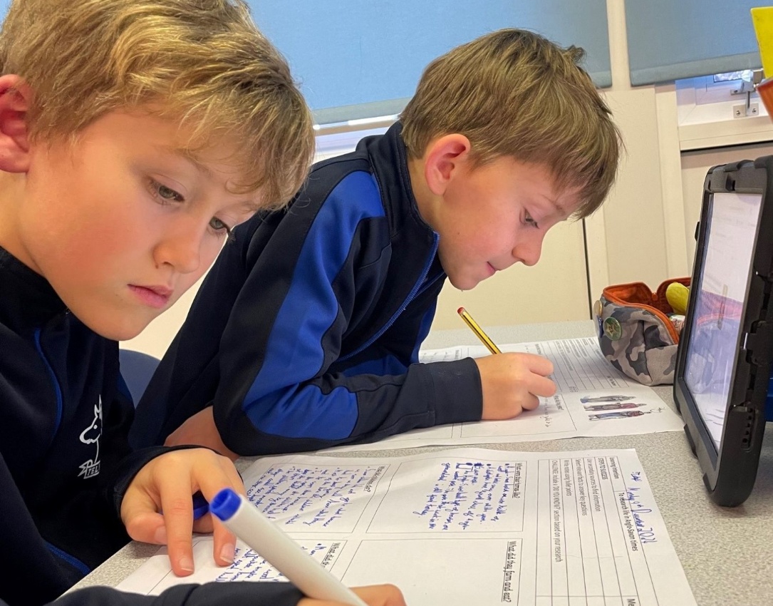 Picture of pupils using iPads for research.